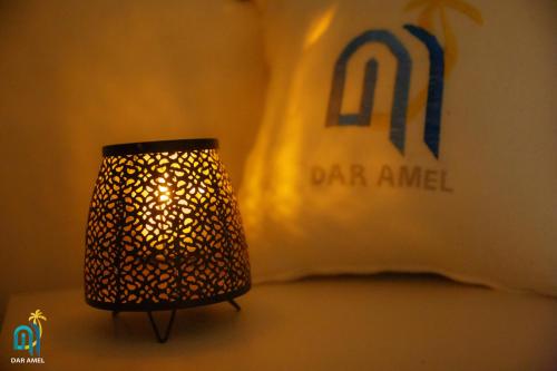 a lamp sitting next to a bed in a room at DAR AMEL in Houmt Souk