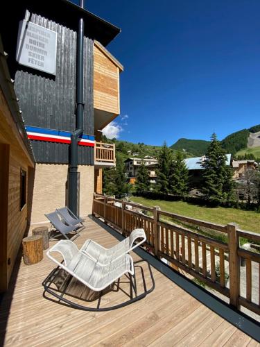 a white chair sitting on a wooden deck at Hôtel 16 | 150 Montagne & Spa Nuxe in Vars