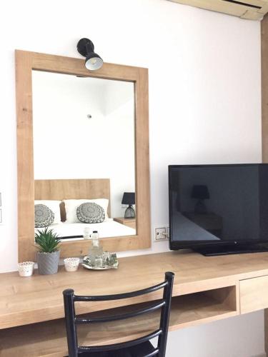 a living room with a television and a mirror at Minoica Beach Apartments in Amoudara Herakliou