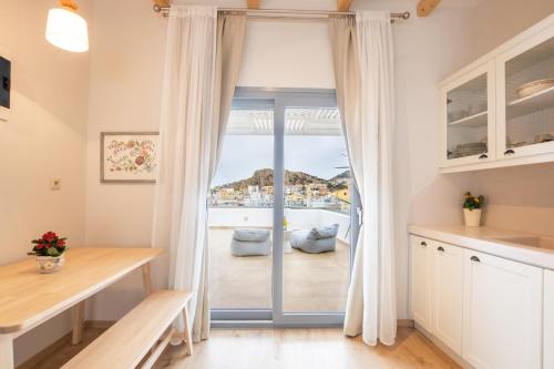 a kitchen with a sliding glass door to a balcony at Olia Boutique Apartments in Karpathos