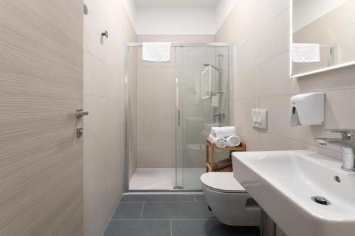 a bathroom with a shower and a toilet and a sink at Polesana Rooms in Pula