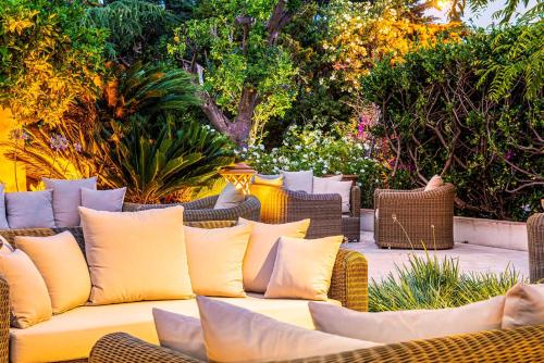 a yellow couch with pillows sitting on a patio at Best Western Premier Montfleuri in Sainte-Maxime