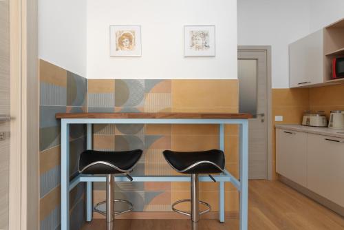 a kitchen with two stools under a table in a kitchen at Polesana Rooms in Pula