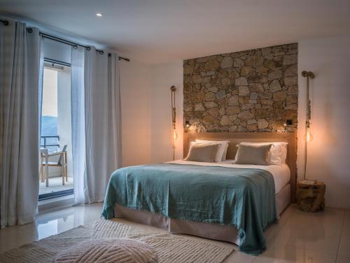 a bedroom with a bed with a stone wall at Hotel A Piattatella in Monticello