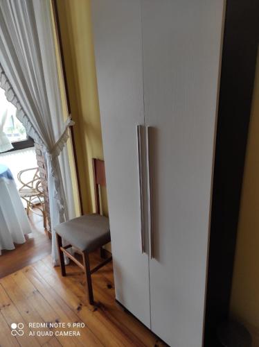 a white refrigerator in a room with a chair at Pensión Rosa in Cabezón de la Sal
