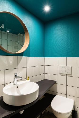 une salle de bain avec un lavabo, des toilettes et un miroir dans l'établissement DIFY Platiere - Hotel de Ville, à Lyon