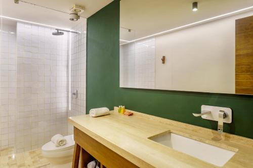 a bathroom with a sink and a toilet and a mirror at Private pool apartment for groups in Tulum