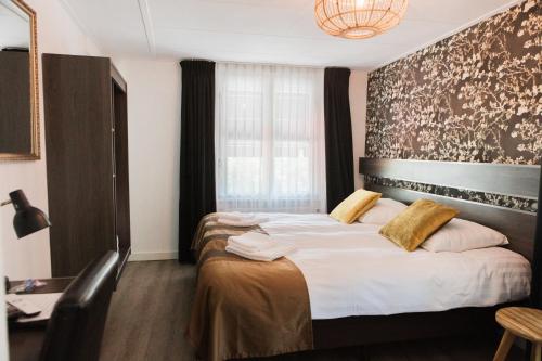 a hotel room with two beds and a window at Hanze Hotel Zwolle in Zwolle