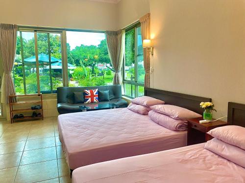 um quarto com 2 camas, uma cadeira e uma janela em Mei Nong Villa em Meinong