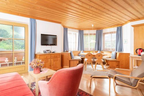 a living room filled with furniture and a tv at Appartements Bernhofer in Saalbach Hinterglemm