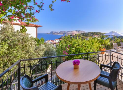 a table and chairs on a balcony with a view of the ocean at Hill House Adult Only in Kas