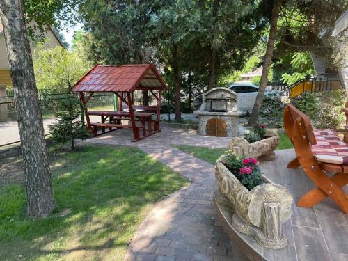 a backyard with a picnic table and a gazebo at Krisztina Apartman 1- Szigethalom in Szigethalom