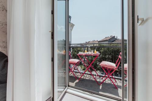 ウィーンにあるHotel Babula am Augartenのガラスドア付きのバルコニー(テーブル、椅子付)