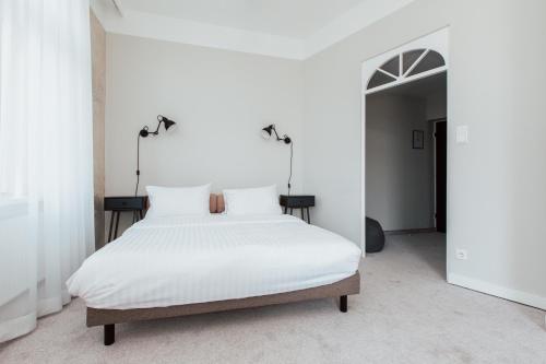 a bedroom with a large white bed with white sheets at Hotel Babula am Augarten in Vienna