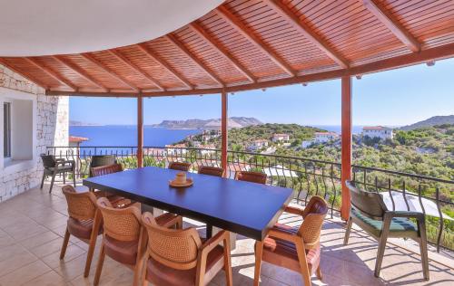 a table and chairs on a balcony with a view of the ocean at Hill House Adult Only in Kas