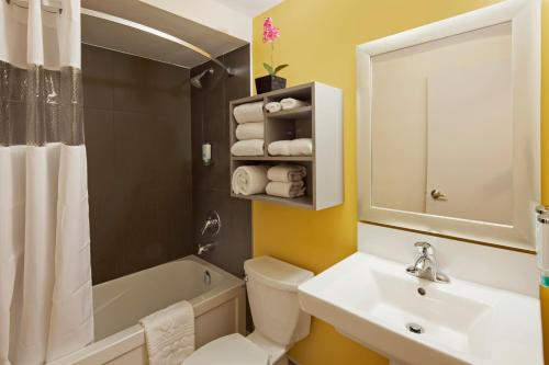a bathroom with a sink and a toilet and a tub at Canadas Best Value Inn Toronto in Toronto