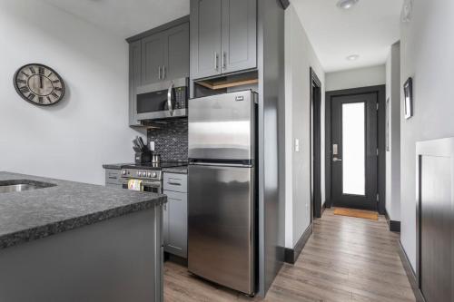 uma cozinha com um frigorífico em aço inoxidável e pisos em madeira em Center City Lofts 508 Unit 2 Close to Downtown and the TART Trail em Traverse City