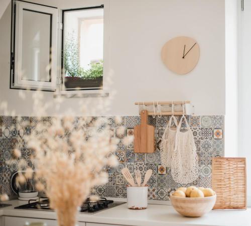 eine Küche mit einer Theke mit einer Uhr an der Wand in der Unterkunft Le Sorelle - casa vacanze in Pisciotta