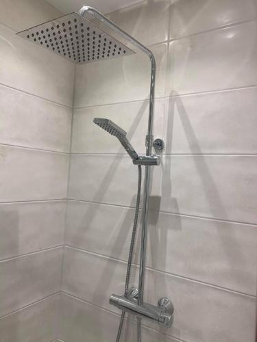 a shower with a shower head in a bathroom at Notodden Sentrum Apartment NO 4 in Notodden