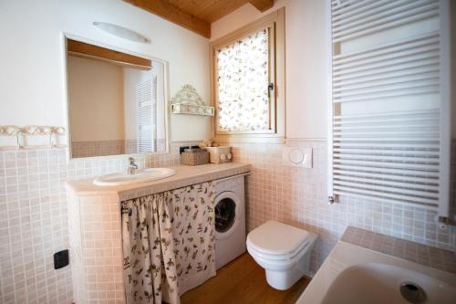 a bathroom with a sink and a washing machine at TRILOCALE ALPES: DIMENTICA L'AUTO E RILASSATI in Ponte di Legno