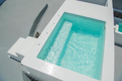 a bath tub filled with water in a sink at AQUA SERENITY LUXURY SUITES SANTORINI in Foinikiá