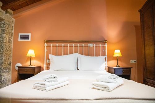 a bedroom with a bed with towels on it at Trapela Areopolis, Boutique Hotel in Areopolis