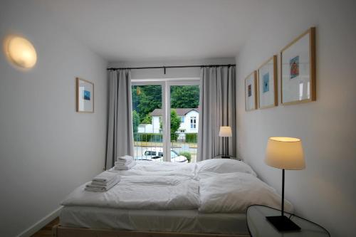 a bedroom with a white bed and a window at Haus Putbus by Rujana in Binz