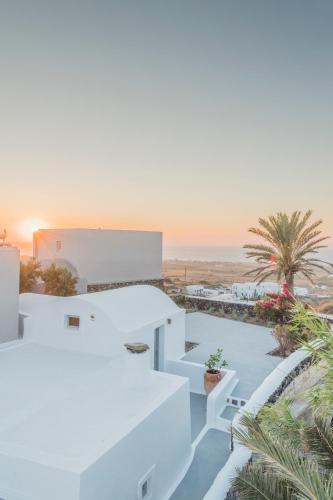 a white house with a view of the ocean at AQUA SERENITY LUXURY SUITES SANTORINI in Foinikiá