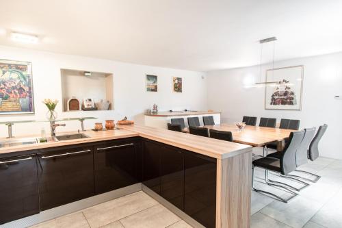 a kitchen with a large wooden table and black chairs at Villa HerMes ArT in Dutovlje