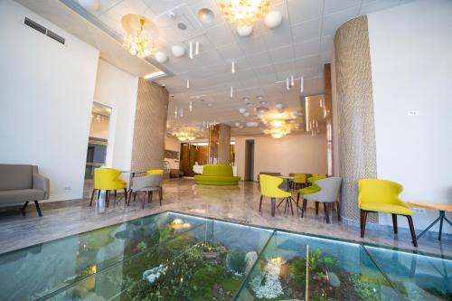a lobby with a dining area and a table and chairs at Hotel Olanesti & Spa Medical in Băile Olăneşti