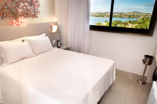 a hotel room with a white bed and white walls at Lagoon Prime Hotel in Lagoa Santa
