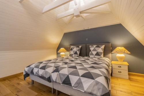 ein Schlafzimmer mit einem schwarzen und weißen Bett und zwei Lampen in der Unterkunft Villa avec piscine sur le domaine d'un château in Carsac-Aillac