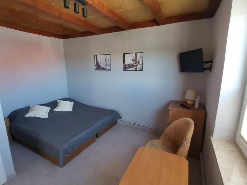 a small bedroom with a bed and a chair at Pokoje Goscinne MAXIM in Białogóra