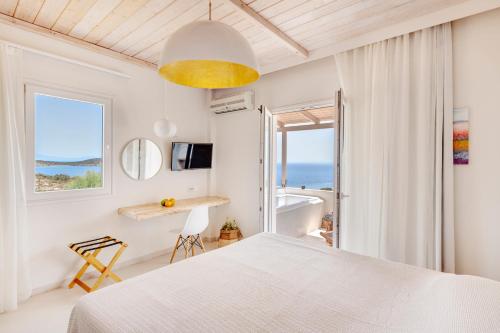 a bedroom with a bed and a view of the ocean at Faros Resort in Azolimnos