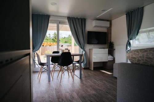 a living room with a table and chairs in a caravan at Lakeside Petzen Glamping in Unterlibitsch