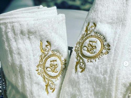 two white towels with gold henna on them at House of Sollys Guesthouse in Manamane