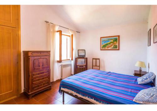 Un dormitorio con una cama y una cómoda y una ventana. en Casa vacanze a pochi passi dal mare, en La Maddalena