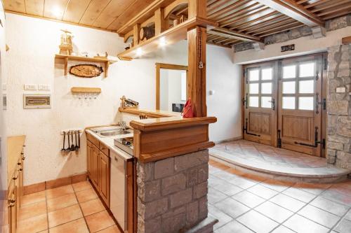 - une cuisine avec des placards en bois et un mur en pierre dans l'établissement Apartment Trieste HerMes arT, à Sežana