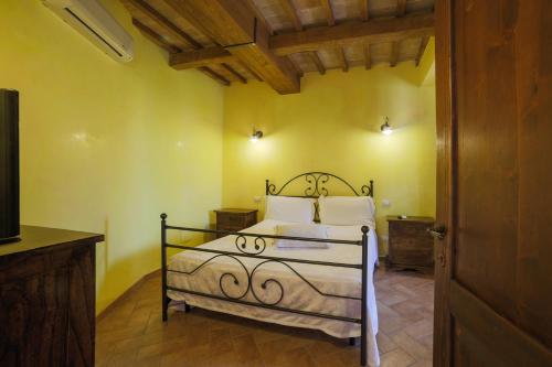 a bedroom with a bed in a room with yellow walls at Appartamento Alvavista1 in Trevi