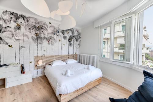 - une chambre avec un lit et une fresque murale de palmiers dans l'établissement L'Hiba - 2-room apartment for 4 people in the centre of Annecy, à Annecy