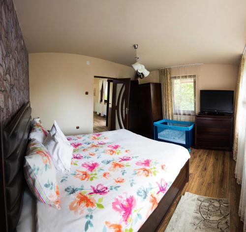 a bedroom with a large bed with a floral bedspread at Erika's Holiday Cottage in Periş