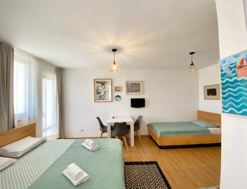 mały pokój z 2 łóżkami i stołem w obiekcie Apartments Rux de Luxe w Barze