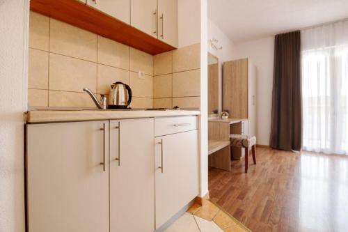 a kitchen with white cabinets and a sink at Apartments Knežević in Neum