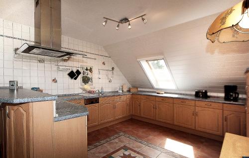 a large kitchen with wooden cabinets and a window at Haus Müritz, FeWo 15 Seeadler in Zielow