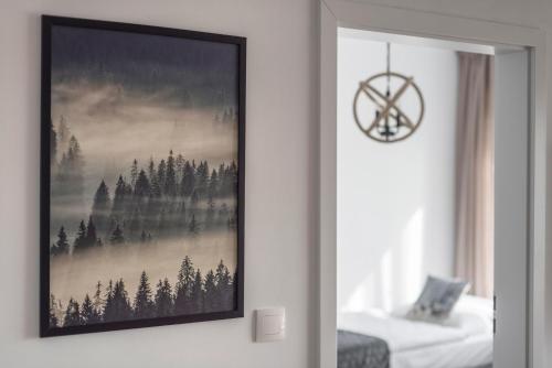 a picture hanging on a wall with a picture of a forest at Wilczarz in Duszniki Zdrój