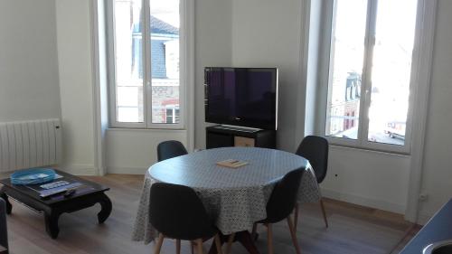 un salon avec une table et une télévision dans l'établissement Dinard-Day, à Dinard