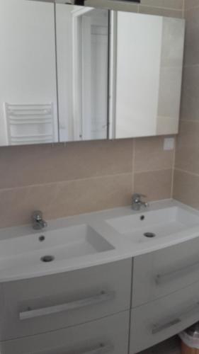 une salle de bain avec un lavabo blanc et un miroir dans l'établissement Dinard-Day, à Dinard