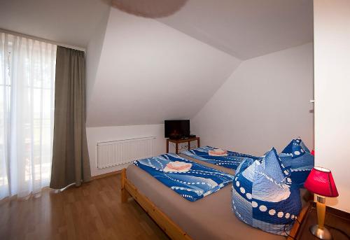um quarto com uma cama com lençóis azuis e uma televisão em Haus Müritz, FeWo 17 Hecht em Zielow