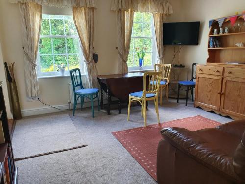 a living room with a couch and a table and chairs at Mandalay Holiday Home in Amesbury