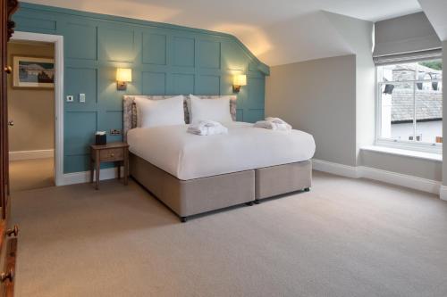 a bedroom with a large bed with a blue wall at The Ro Hotel Windermere in Bowness-on-Windermere